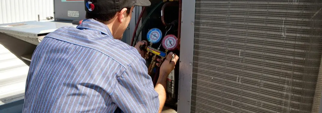 HVAC technician servicing a condenser unit in Half Moon Bay