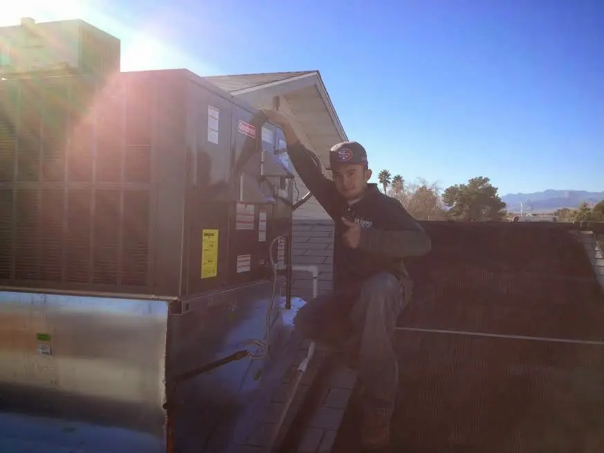 HVAC technician performing Air Duct Cleaning on a rooftop unit in Half Moon Bay